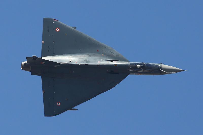 A Tejas in a knife-edge bank showing its delta-wing planform against a blue sky