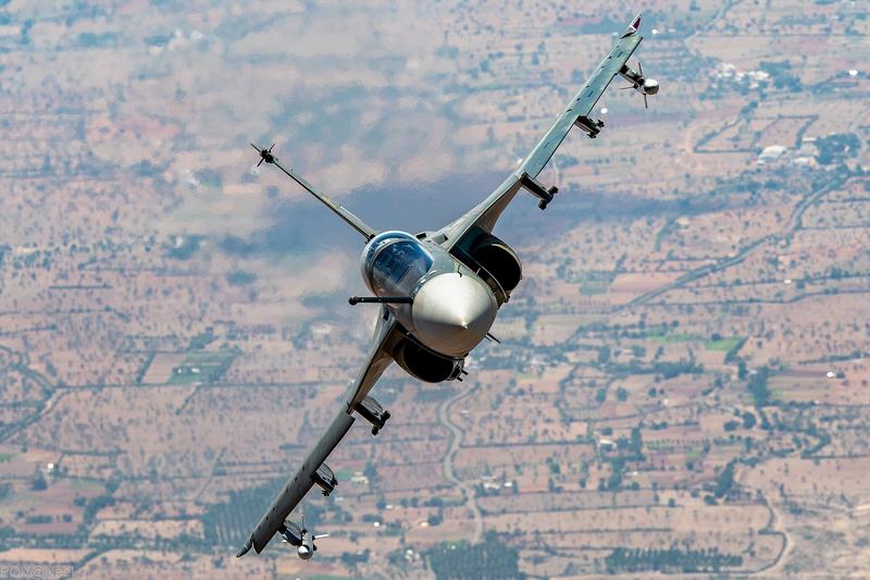 A Tejas seen head-on as it banks over a patchwork of fields