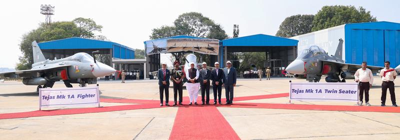 Tejas Mk1A fighter and Mk1A twin-seater parked either side of a red carpet, with officials between them