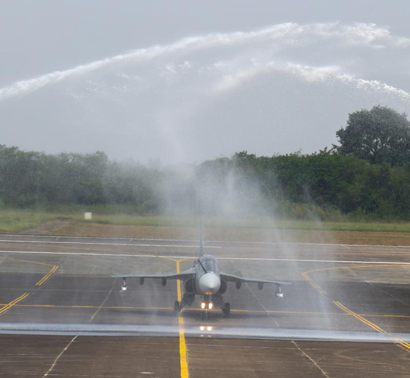 Tejas Mk1A taxiing through an arch of water from two fire tenders