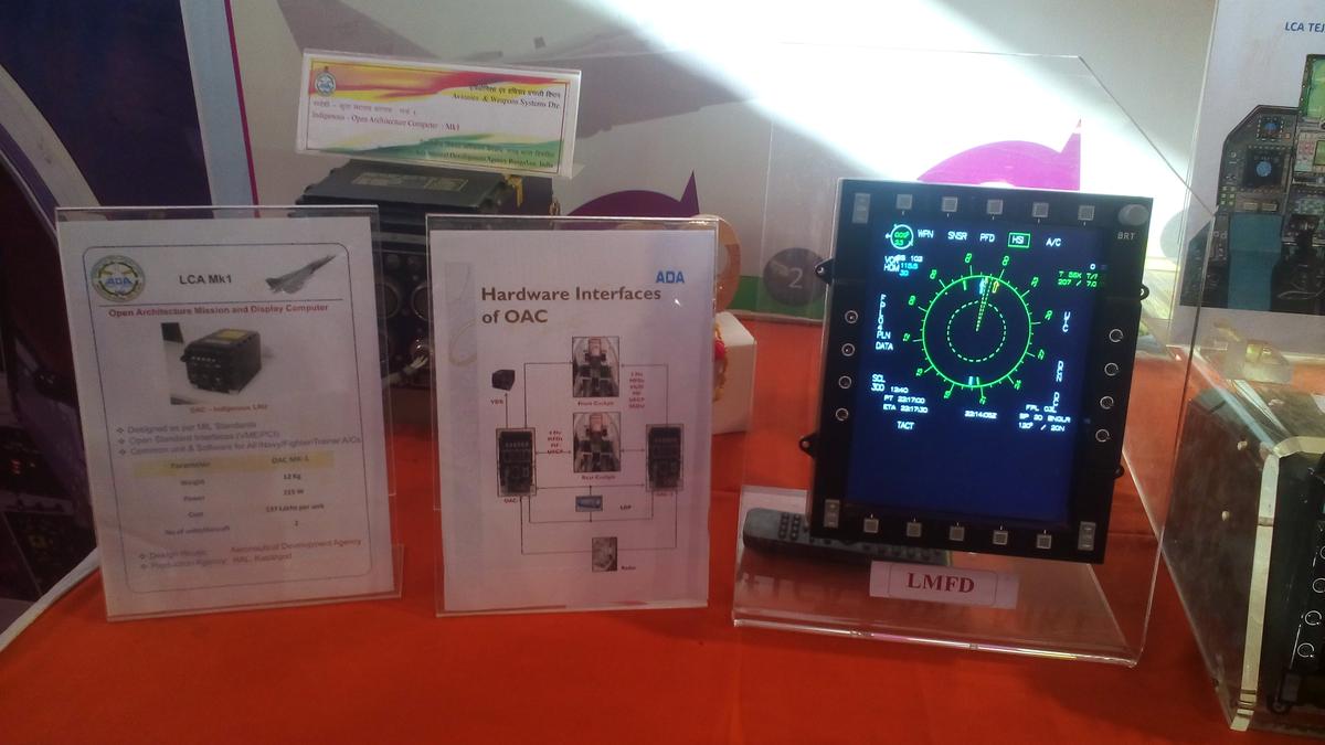 Exhibit of the Tejas Open Architecture Computer information boards beside a multi-function display showing a radar page